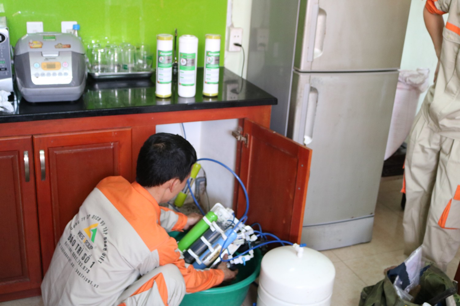 Thợ kỹ thuật hướng dẫn khách hàng bảo dưỡng máy lọc nước tại nhà